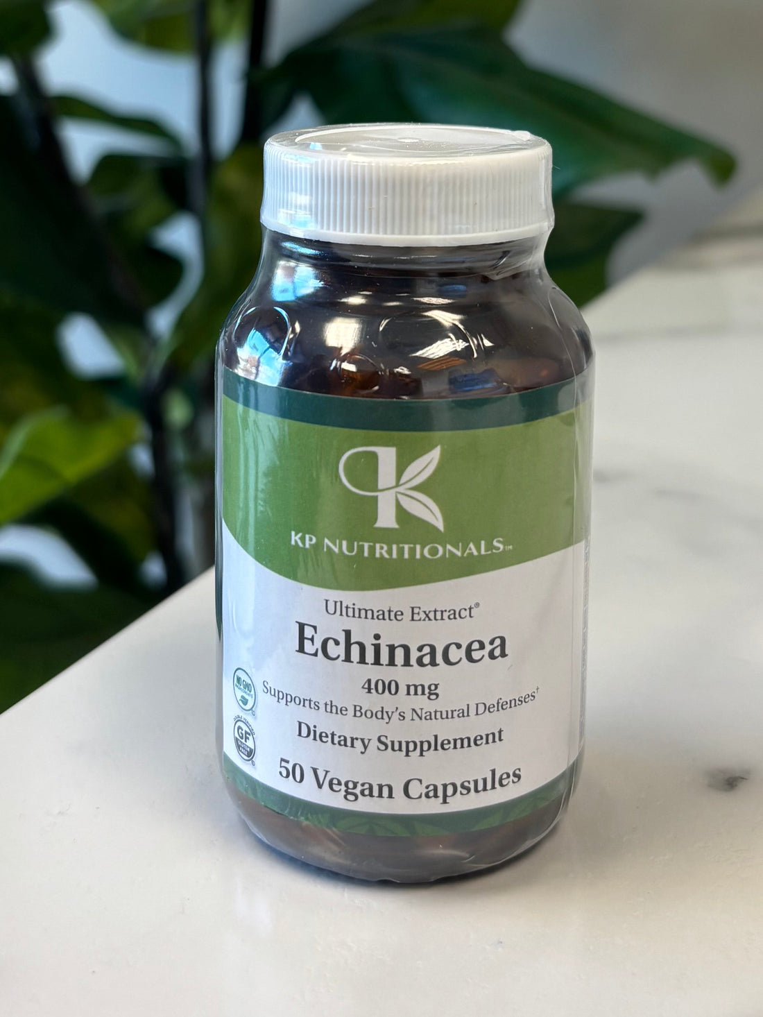Echinacea supplement on a marble surface with a plant in the foreground